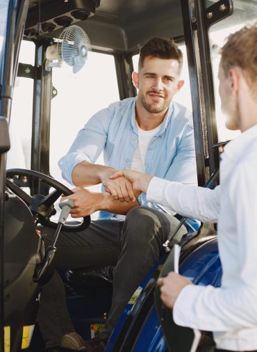 Agronomist choosing a new planter. Man at the outdoor ground of the shop. Agricultural machinery.